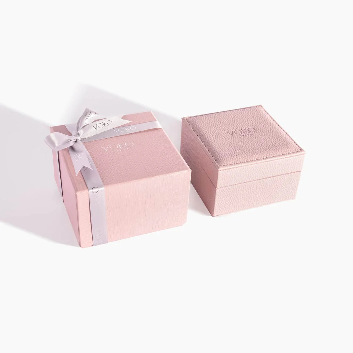 Pink jewelry box with a ribbon on a white background