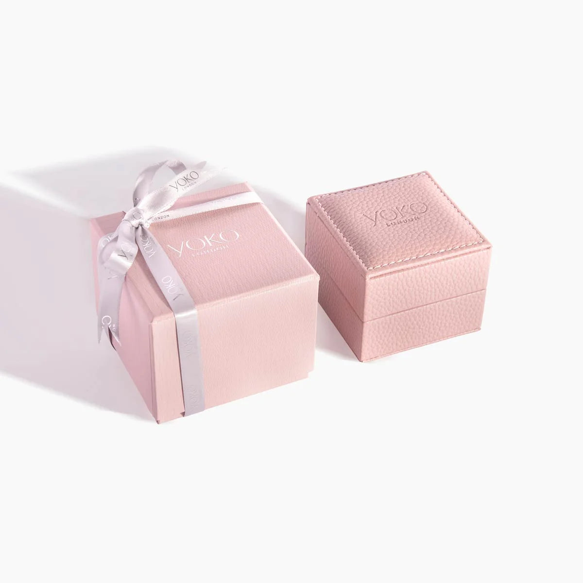 Pink jewelry box with a ribbon and 'Yoko London' branding on a white background