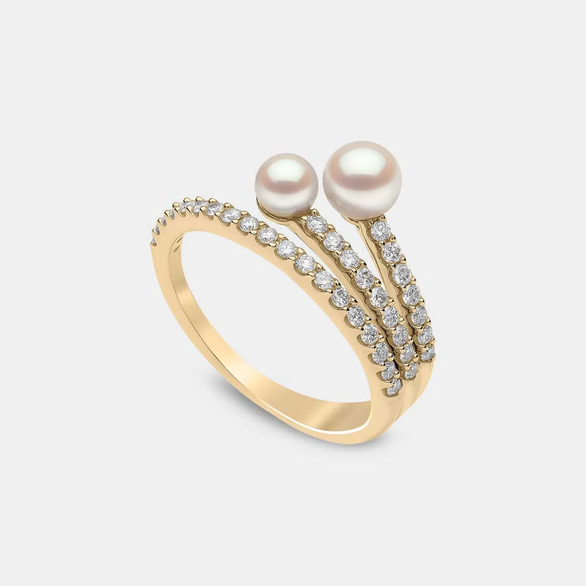 Yellow gold pearl and diamond twist fashion ring on grey background, side angle view