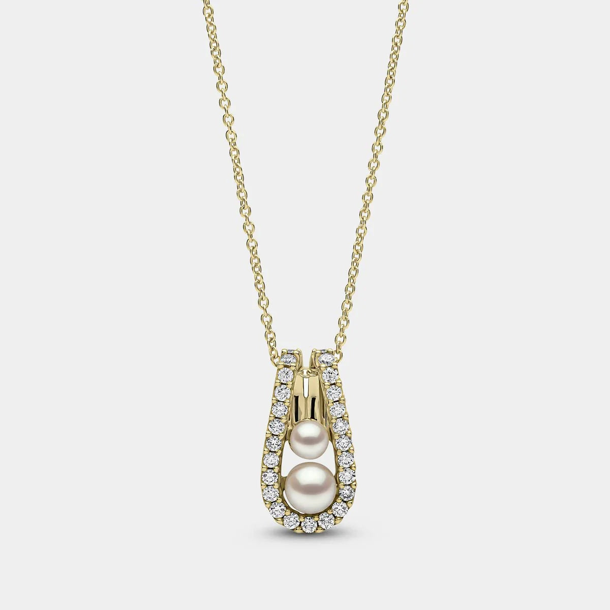 Yellow gold pearl and diamond pendant necklace on grey background, front view
